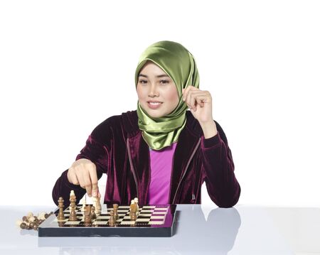 active young woman playing chess over white backgroundの写真素材