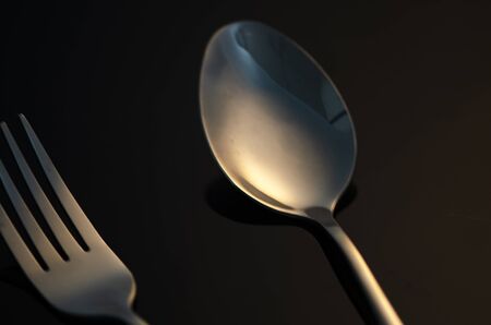 fork and silver spoon on dark backgroundの写真素材