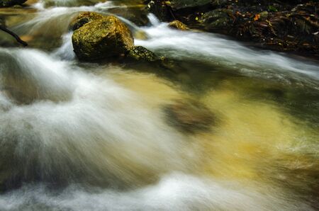 Beautiful tropical waterfall in lush surrounded by green forest.wet rock and moss.selective focus shot.の写真素材