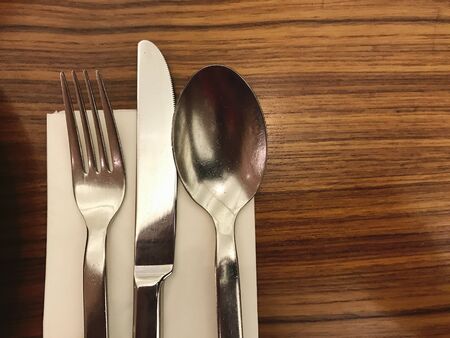 fork and silver spoon on wooden tableの写真素材