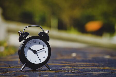 Vintage alarm clock on yellow background with bokeh