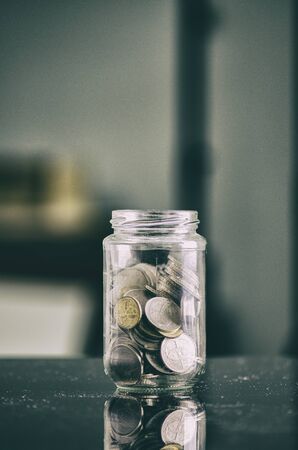 financial concept,coin in transparent glass jar over shallow depth of field background の写真素材