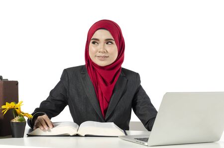 young businesswomen or student in hijab sitting at her workplace against white backgroundの写真素材