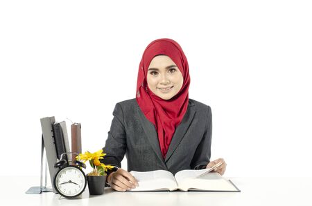 young businesswomen or student in hijab sitting at her workplace in light officeの写真素材