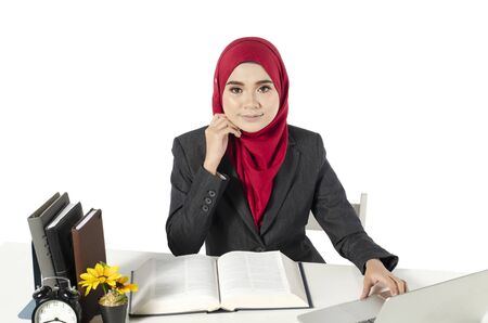 young businesswomen or student in hijab sitting at her workplace against white backgroundの写真素材