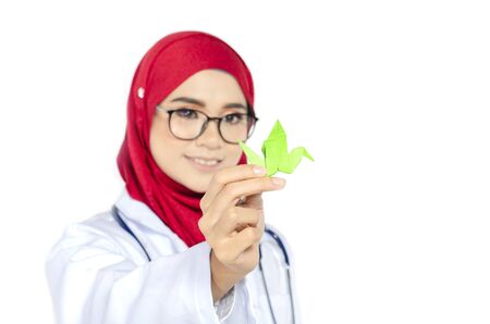 medical healthcare concept, cropped image of young doctor standing and holding origami bird on white backgroundの写真素材