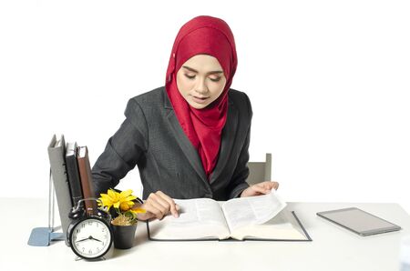 young businesswomen or student in hijab sitting and read the book against white backgroundの写真素材