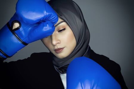 Business challenge concept, hapyy face young businesswoman in suit with boxing glove.の写真素材