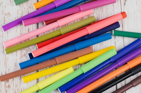 Back to school and offices stationary concept, stack of colored pens markers on wooden deskの写真素材
