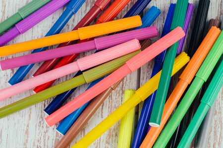 Back to school and offices stationary concept, stack of colored pens markers on wooden deskの写真素材