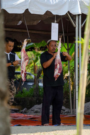 Kuala Terengganu, Malaysia - September 3, 2017: Group of Malaysian Muslims community butchering cow's meat during Eid Al-Adha Mubarak celebration, the Festival of Sacrifice to remember the story of Prophet Abraham and his son, Ismaelのeditorial素材