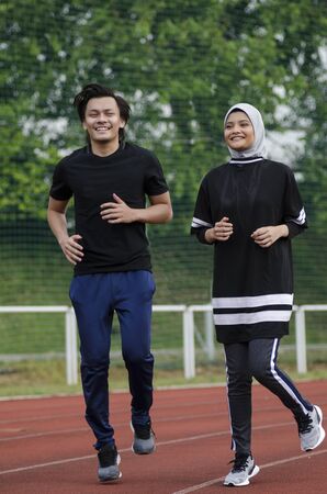 young happy couple enjoying in a healthy lifestyle, warming up and stretching before joggingの写真素材