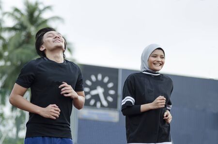 young happy couple enjoying in a healthy lifestyle, warming up and stretching before joggingの写真素材