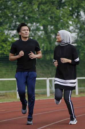 young happy couple enjoying in a healthy lifestyle, warming up and stretching before joggingの写真素材