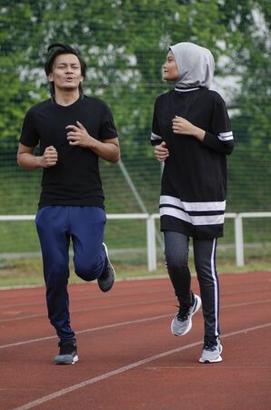 young happy couple enjoying in a healthy lifestyle, warming up and stretching before joggingの写真素材