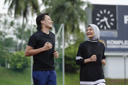 young happy couple enjoying in a healthy lifestyle, warming up and stretching before joggingの写真素材