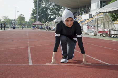 young woman runner doing stretching exercise, preparing for morning workoutの写真素材