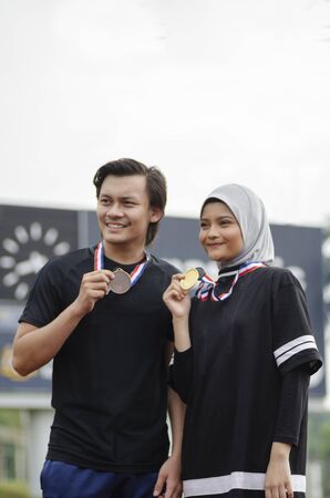 young sport people with smile face holding medal and enjoying their successの写真素材
