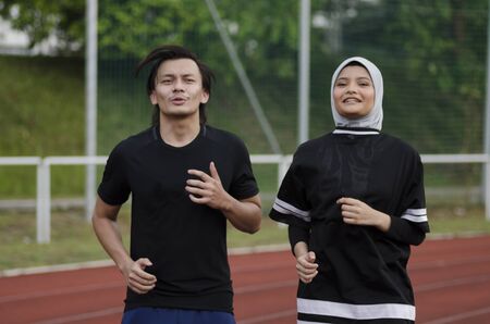 young happy couple enjoying in a healthy lifestyle, warming up and stretching before joggingの写真素材
