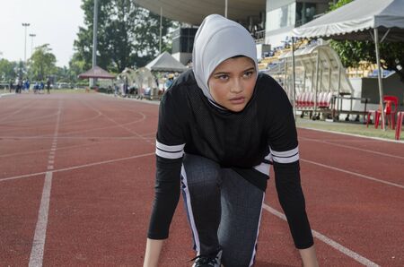 young woman runner doing stretching exercise, preparing for morning workoutの写真素材