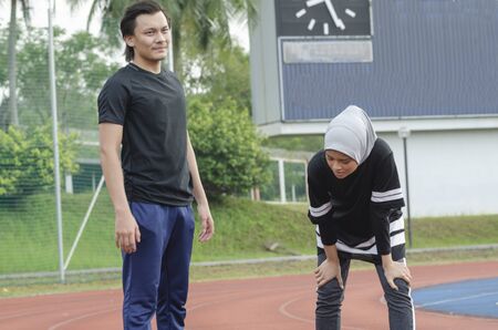 young happy couple enjoying in a healthy lifestyle, warming up and stretching before joggingの写真素材