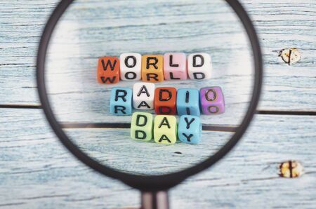 magnified image of colorful World Radio Day word cube on wooden backgroundの写真素材