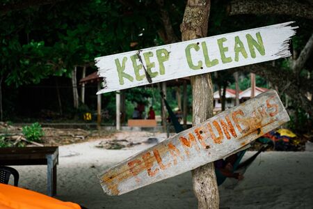 pieces of wood with hand painted beach activities attached to tree stump in Pangkor Island, Perak State, Malaysiaの写真素材