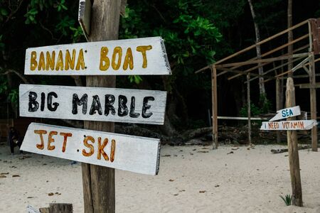 pieces of wood with hand painted beach activities attached to tree stump in Pangkor Island, Perak...