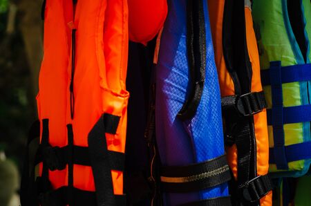 Close-up group of Life jacket or life vest hanging under the shelter at Pangkor Island, Malaysiaの写真素材