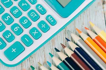 Back to school and offices stationary concept, stack of colored pens markers and calculator on wooden deskの写真素材