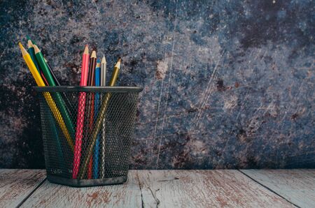 Back to school and offices stationary concept, stack of colored pens markers In a metal case over dark backgroundの写真素材
