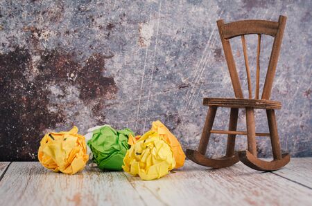 wooden chair and crumple paper on floorの写真素材
