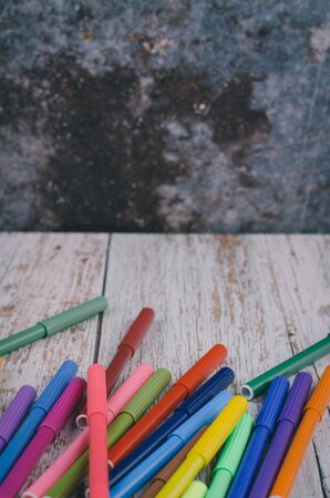 Back to school and offices stationary concept, stack of colored pens markers on wooden deskの写真素材