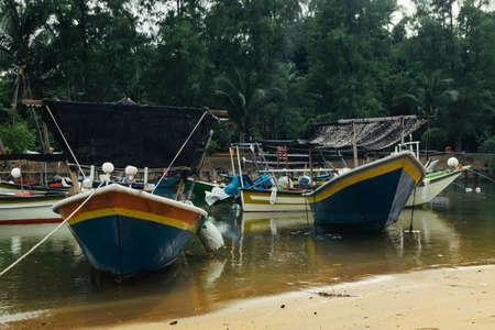 Beautiful view at Traditional fishing village with lovely sky and fishing boat moored near the shoreの写真素材
