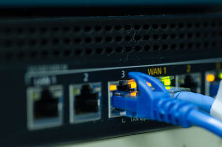 network cable and switch port in the data center. selective focus shot. noise and grain effect due to low lightの写真素材