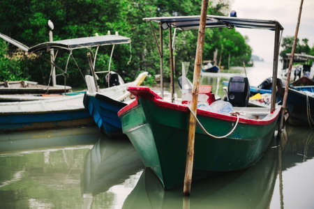 Beautiful view at Traditional fishing village with lovely sky and fishing boat moored near the shoreの写真素材