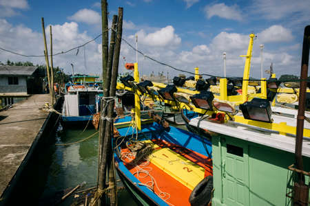 Beautiful view at Traditional fishing village with lovely sky and fishing boat moored near the shoreの写真素材