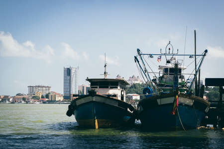 Beautiful view at Traditional fishing village with lovely sky and fishing boat moored near the shoreの写真素材