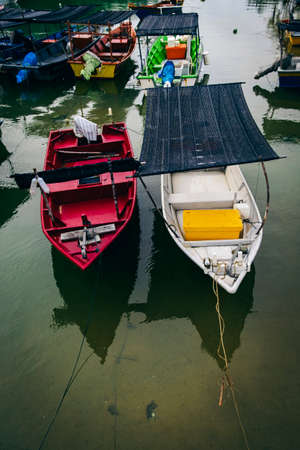 Beautiful view at Traditional fishing village with lovely sky and fishing boat moored near the shoreの写真素材