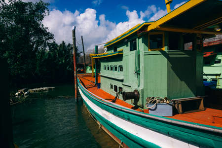 Beautiful view at Traditional fishing village with lovely sky and fishing boat moored near the shoreの写真素材