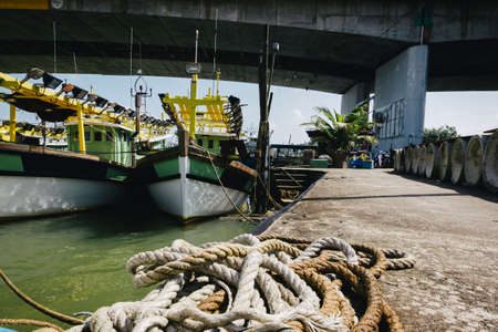 Beautiful view at Traditional fishing village with lovely sky and fishing boat moored near the shoreの写真素材