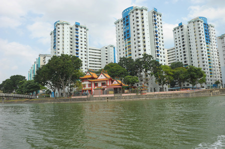 Singapore, Feb 25, 2014 - High-rise public housing and Chinese temple built along the river bank of Kallang river taken in the day on Feb 25, 2014のeditorial素材