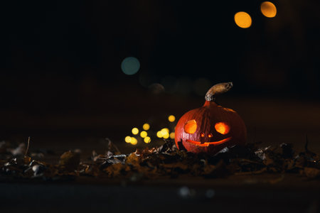 Glowing mystical Halloween pumpkin on the road at nightの写真素材