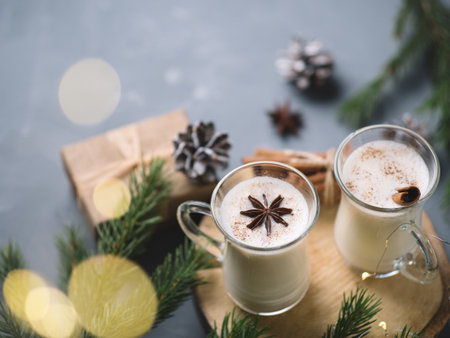 Traditional winter and Christmas drink egg nog in beautiful glass cups on the table with cinnamonの写真素材