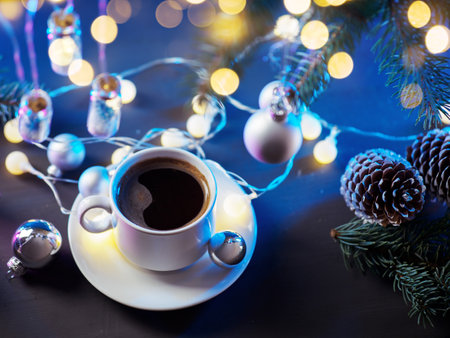 Morning festive white cup coffee on the table with Christmas tree branches, vintage garland and cones. Christmas timeの写真素材