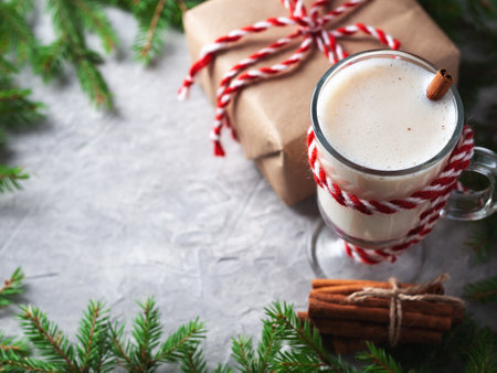 Christmas drink egg nog on wooden table with tree branchesの写真素材