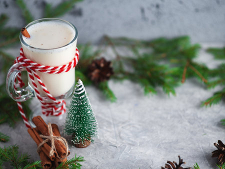 Christmas drink egg nog on wooden table with tree branchesの写真素材
