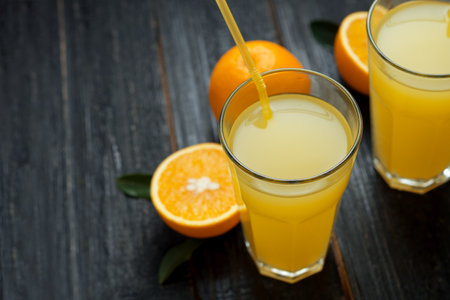 Fresh cold orange juice on wooden dark background with copyspaceの写真素材
