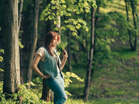 Cute Caucasian young woman with a bouquet of lilies of the valley in the forestの写真素材
