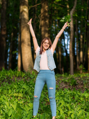 Happy young woman with Lily of the valley bouquet in the Parkの写真素材